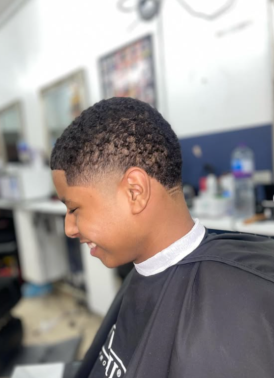 Young customer with a taper fade and defined curl texture, cut at Macveli Cuts on Old Kent Road
