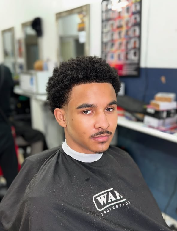 Curly textured afro with a soft taper through the temples, finished at Macveli Cuts, London SE1